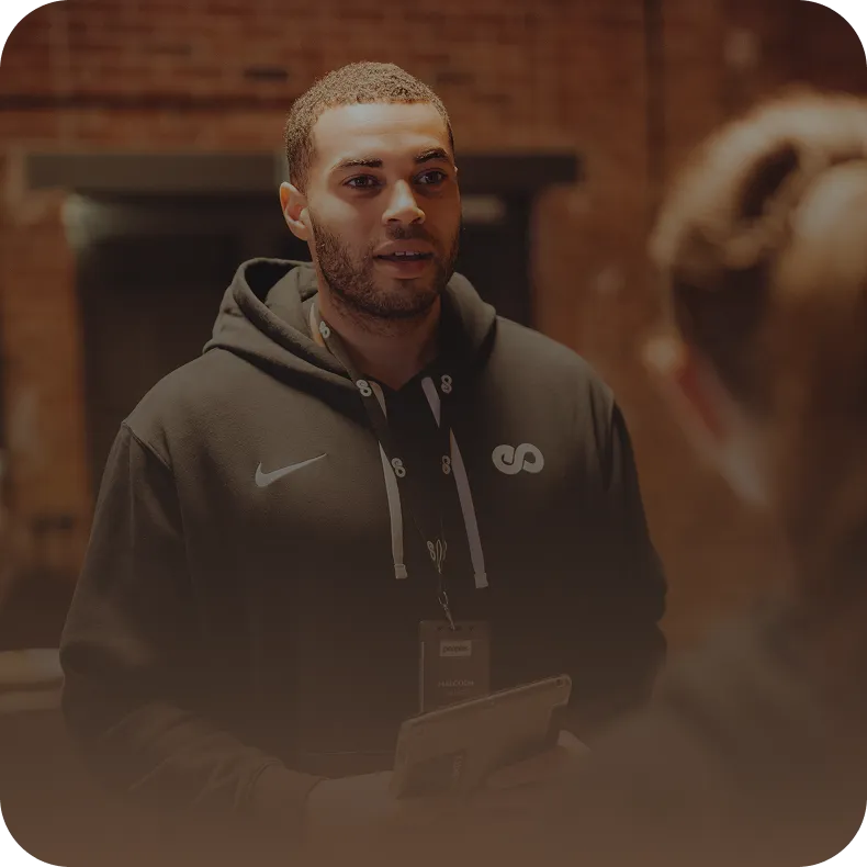 Peoples Trainer im persönlichen Gespräch mit Mitglied – engagiertes Team an deiner Seite